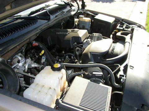 1995 Ford Bronco - The engine bay of a vehicle, the VORTEC engine cover and a prominent coolant reservoir.