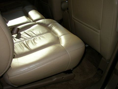1995 Ford Bronco - Interior view of tan leather seats, showing the stitching and seatbelt.