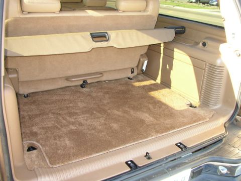 1995 Ford Bronco - The cargo area of a 1995 Ford Bronco shows its carpeted floor and folded rear seats.