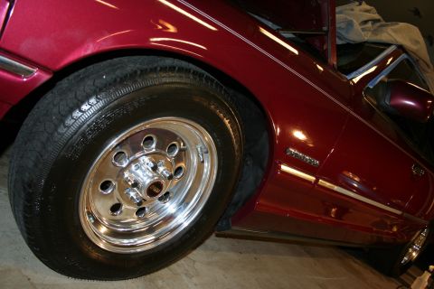 1992 Ford Crown Victoria - A close-up of a red 1992 Ford Crown Victoria, its side profile and custom chrome wheels.