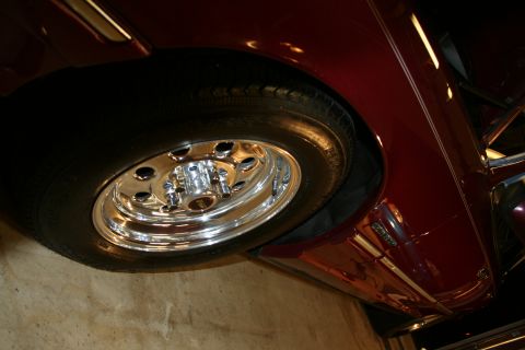 1992 Ford Crown Victoria - Detail shot of a car's wheel and fender, color is dark red with chrome accents.