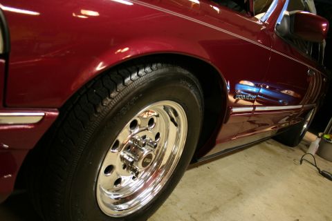 1992 Ford Crown Victoria - The side profile of a maroon 1992 Ford Crown Victoria is visible, highlighting its chrome wheel and trim details.