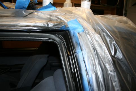 1990 Ford Mustang - Car interior masked off with plastic and tape, likely for painting or detailing work.