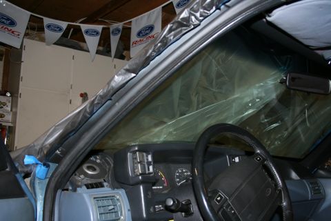 1990 Ford Mustang - Interior view of a 1990 Ford Mustang, prepared for work with plastic sheeting covering the windshield.