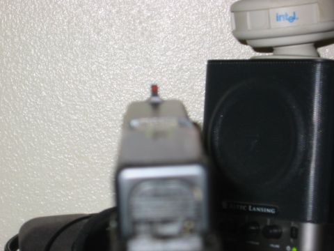 1996 Ford Bronco - Close-up view of pistol sights, with electronic devices in the background.