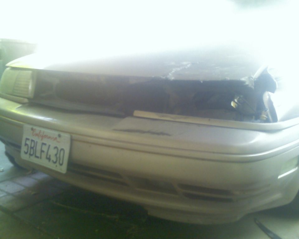 1991 Ford Taurus with a damaged front end and a California license plate 5BLF430