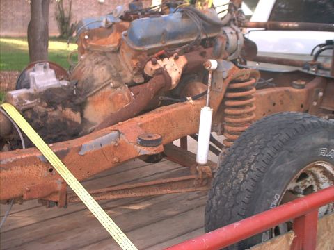 1994 Ford Bronco - A heavily rusted vehicle chassis, including the engine and suspension, is visible on a trailer.