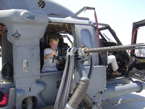 1996 Ford F-250 - A young boy sits in the cockpit of a helicopter, aiming a mounted machine gun.