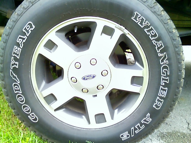 Goodyear Wrangler AT/S tire on a silver 5-spoke wheel with a Ford logo center cap