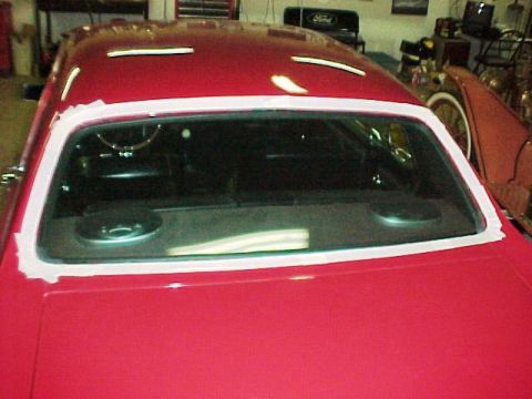 1967 Mercury Cougar - Rear interior view of a red 1967 Mercury Cougar, showing the rear window and speakers on the deck.