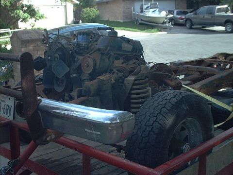 1994 Ford Bronco - Vehicle engine and chassis are disassembled and loaded onto a trailer for transport.