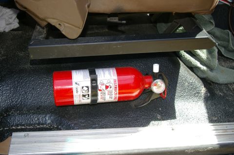 1986 Ford Bronco - A fire extinguisher is visible on the floor of a vehicle's interior.