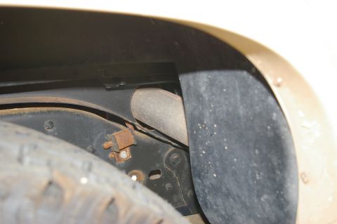 1986 Ford Bronco - Detail shot of the undercarriage, showing the tire and suspension elements within the wheel well.