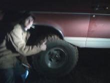 1992 Ford Bronco - A person gives a thumbs up next to the side of a maroon and white SUV in the dark.