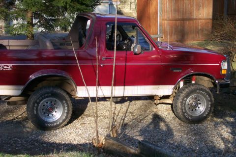 1993 Ford Bronco - This red Ford Bronco features a removable top and off-road tires.
