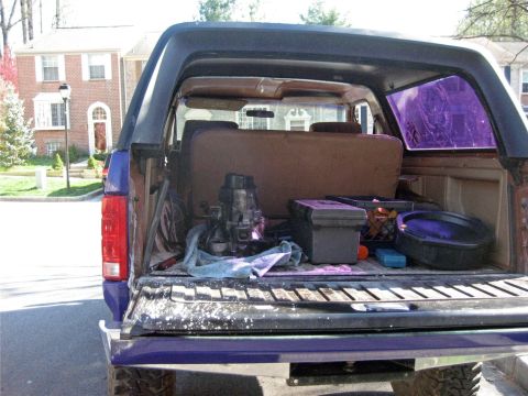 1993 Ford Probe - This 1993 Ford Bronco is seen from the rear with its tailgate open, revealing a collection of tools and automotive parts.