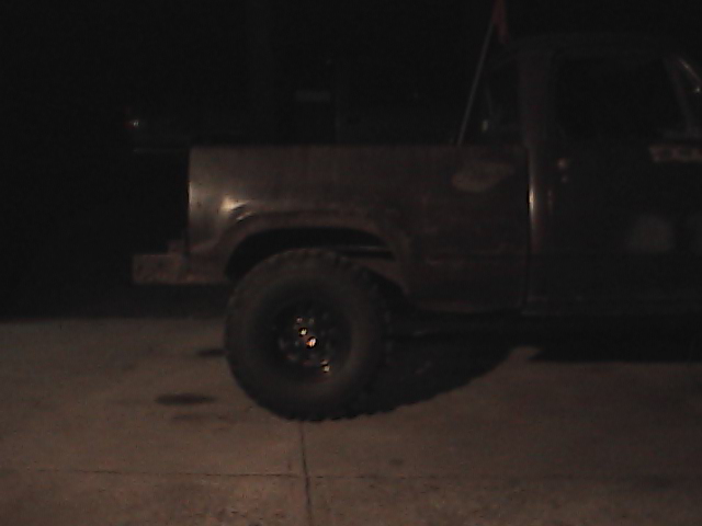 Rear quarter panel and wheel of a pickup truck. Watermark says SUPERMOTORS
