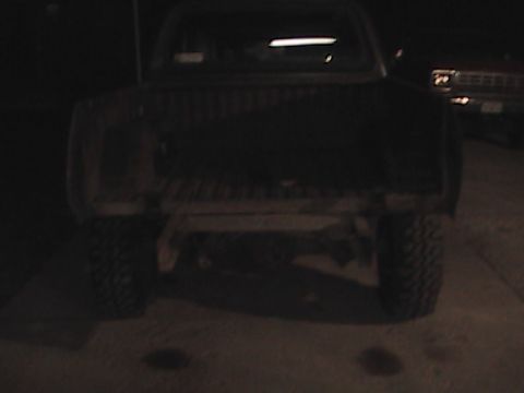 1980 Dodge Magnum - Rear view of a dark pickup truck at night, with another vehicle partially visible.