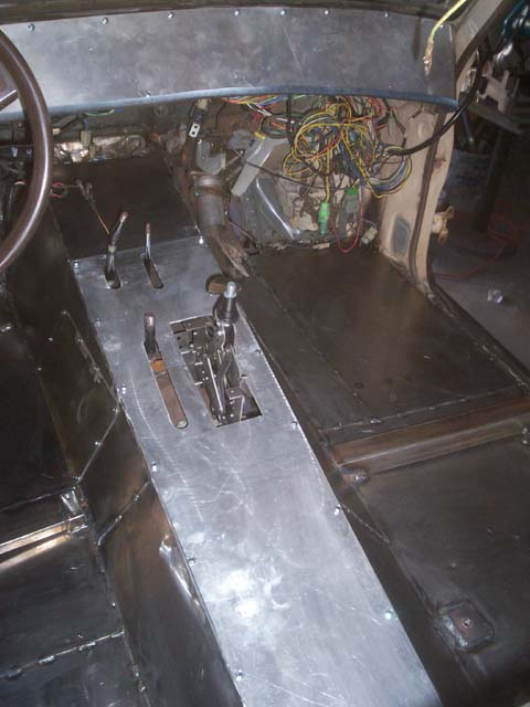 1982 Toyota 4Runner - The interior of a vehicle shows extensive custom metal fabrication on the floor and center console, with exposed wiring.