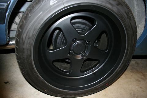 1990 Ford Mustang - A close-up view of a black aftermarket wheel and tire on a vehicle.