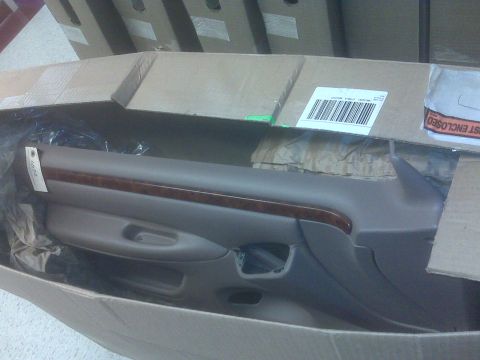 1996 Ford Bronco - A car door panel, possibly for a sedan, is shown inside its shipping box.