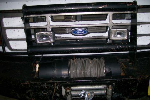 1992 Ford C-350 (Centurion Conversions) - Front view of a white Ford truck, showing the grille, bull bar, and a winch mounted below.