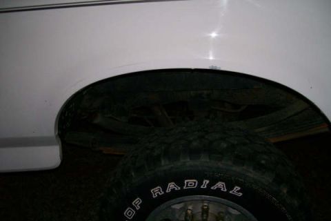 1992 Ford C-350 (Centurion Conversions) - Close-up of a truck's rear wheel well and tire, showing suspension components.