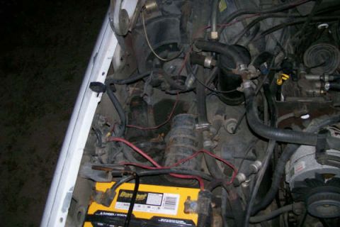 1992 Ford C-350 (Centurion Conversions) - View of the engine bay, showing the battery and various hoses and wiring.