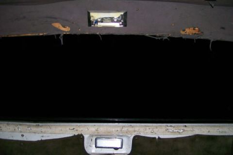 1992 Ford C-350 (Centurion Conversions) - Damaged headliner in a vehicle interior, with a reflection visible in the rear window.