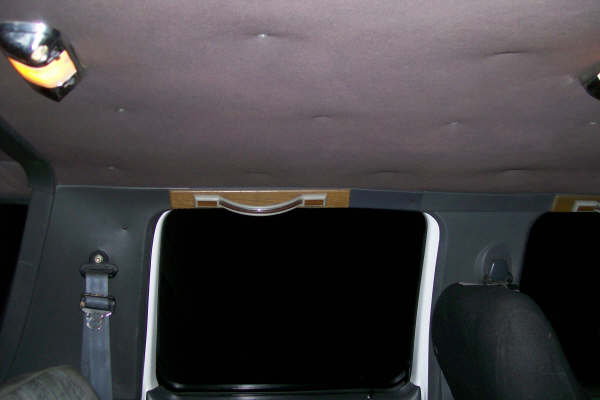 Interior shot of a van, showing the headliner, dome lights, and rear seats