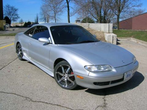 1994 Mazda MX-6 - Silver 1994 Mazda MX-6 coupe with aftermarket wheels parked on asphalt.