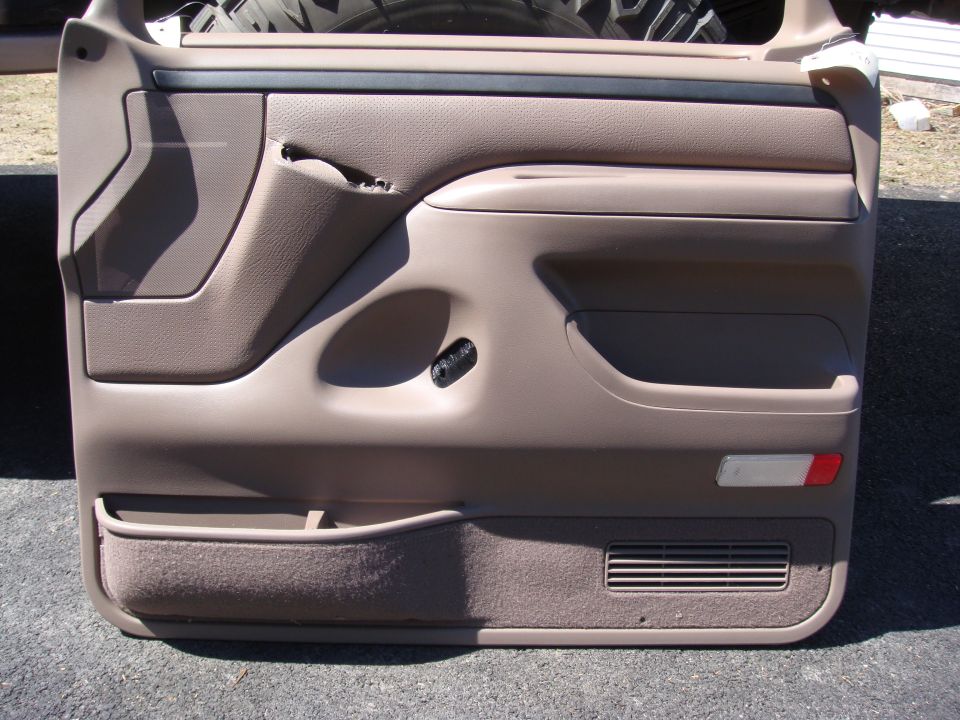 1996 Ford Bronco door panel, tan interior, with storage pockets and speaker grille