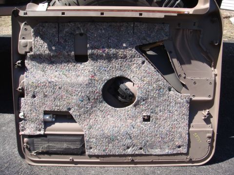 1996 Ford Bronco - The interior side of a vehicle door panel, showing insulation and mounting points for components.