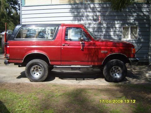 1989 Ford Bronco - This 1989 Ford Bronco is shown from the side, parked in front of a house.