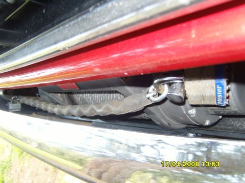 1989 Ford Bronco - Winch and tow strap locked with a Master padlock, mounted on a vehicle's front end.