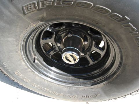 1986 Ford Bronco - Close-up of a BFGoodrich tire and black rim, a chrome hub assembly.
