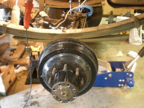 1993 Ford Bronco - Close-up view of a vehicle's rear axle and suspension components, including a drum brake assembly.