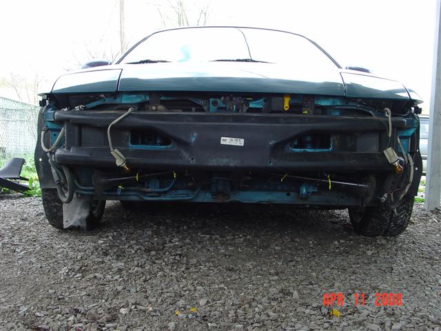 Teal car front, bumper removed, showing internal components