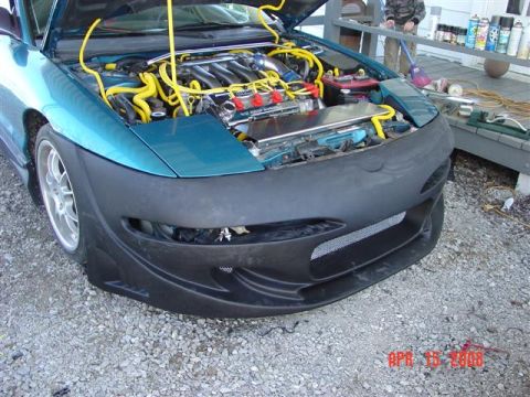 1993 Ford Probe - Front view of a 1993 Ford Probe with its hood open, revealing the engine and an aftermarket bumper.