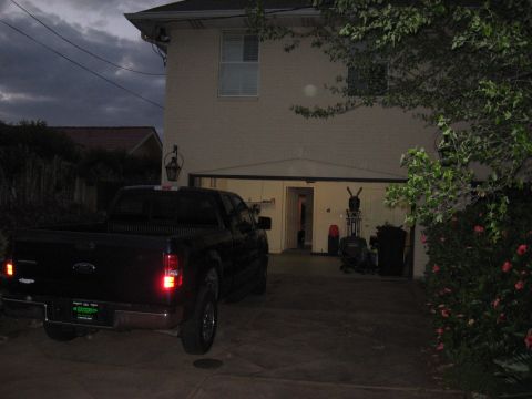 2006 Ford F-150 - A black 2006 Ford F-150 pickup truck is parked in front of a garage.