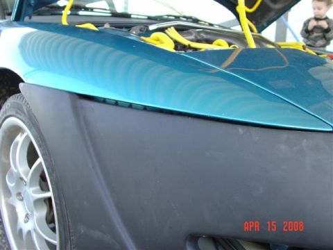 1993 Ford Probe - Close-up of a teal car's front fender and wheel with the hood open.
