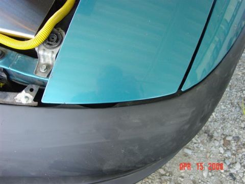 1993 Ford Probe - Detail shot of a car's front end, showing the fender and bumper assembly with visible wiring.