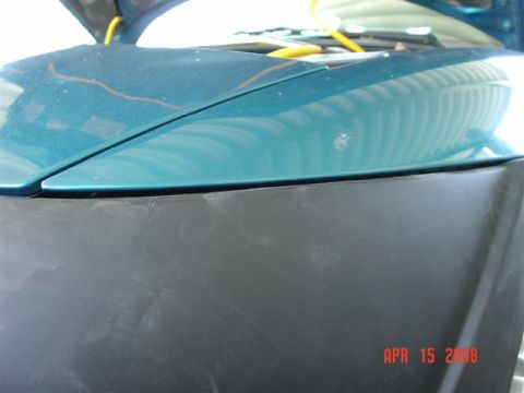 1993 Ford Probe - Close-up of a teal car's hood and black bumper, showing a date stamp and website from Supermotors.net.