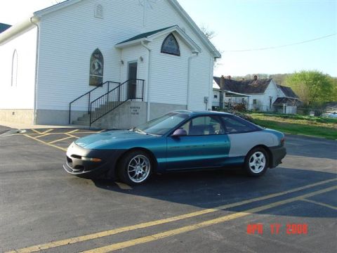 1993 Ford Probe - A 1993 Ford Probe is parked in front of a church on a sunny day.