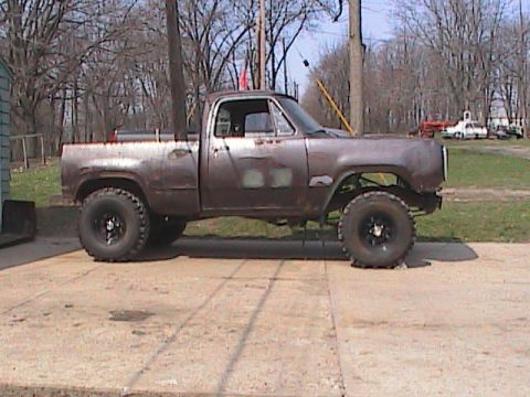 1980 Dodge Magnum - A weathered pickup truck sits on a concrete pad, showing signs of modification and age.