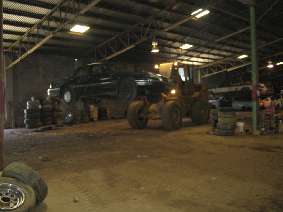 Dark 1985 Ford Crown Victoria LTD on forklift in warehouse
