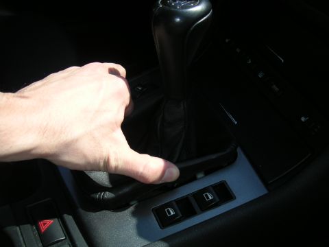 2002 BMW M3 - A hand is shown adjusting the manual gear shift knob and boot inside a vehicle. The registry claims it is a 2002 BMW M3, but this is not ve…
