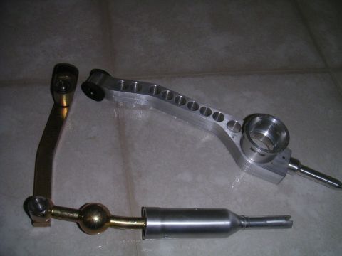 2002 BMW M3 - Two sets of shift linkage components are displayed, one with a brass ball joint and the other an aluminum lever with a machined housing.
