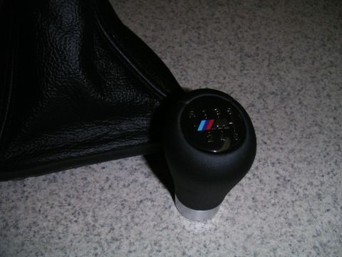 2002 BMW M3 - A close-up of a BMW M shift knob and its leather boot, showing the gear pattern and M logo.