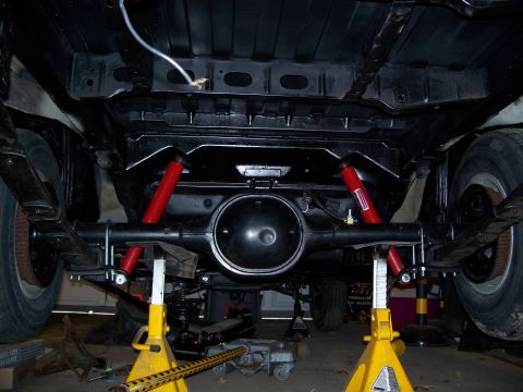 1971 Ford Ranchero - The rear suspension and differential of a vehicle are visible, supported by yellow jack stands.